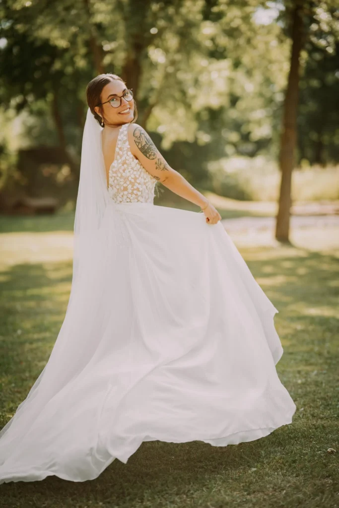 Braut schwingt ihr Brautkleid im Park