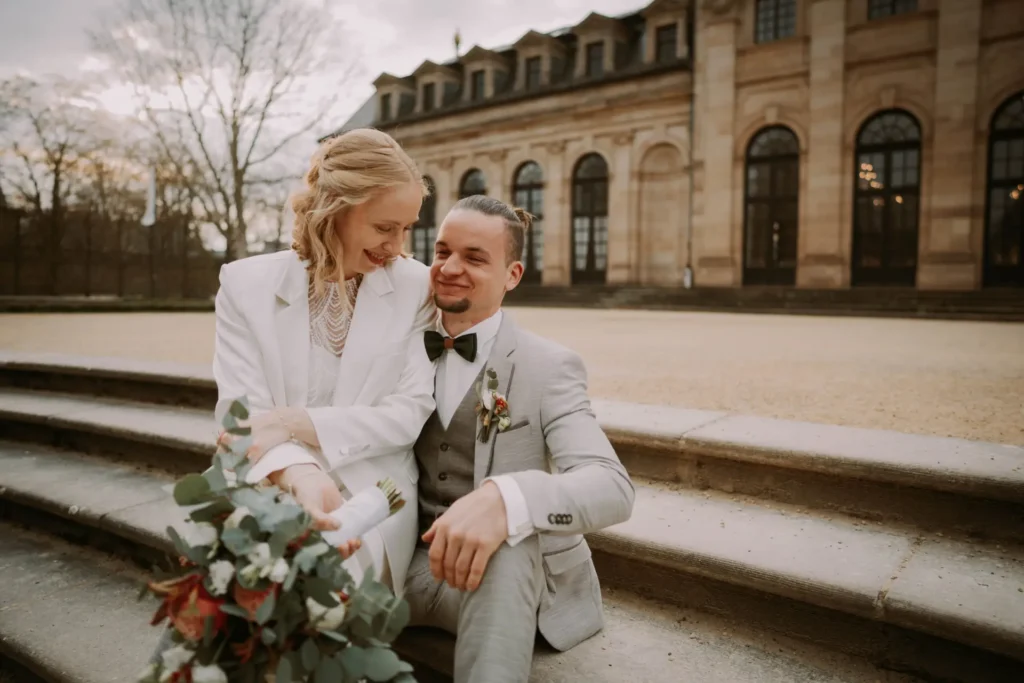 Stella und Alex lachend auf den Steintreppen vor der Orangerie