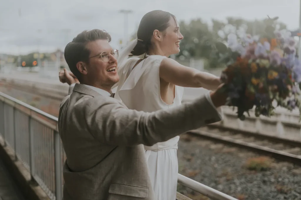 Konstantin lacht mit Gwen an den Bahngleisen